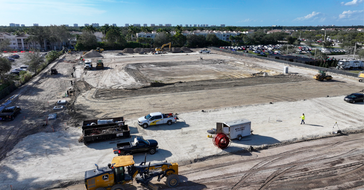 Aerial view of a large construction site with machinery and graded earth.